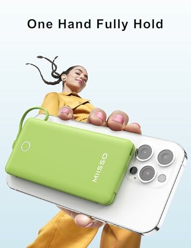 Person holding a green power bank attached to a smartphone.