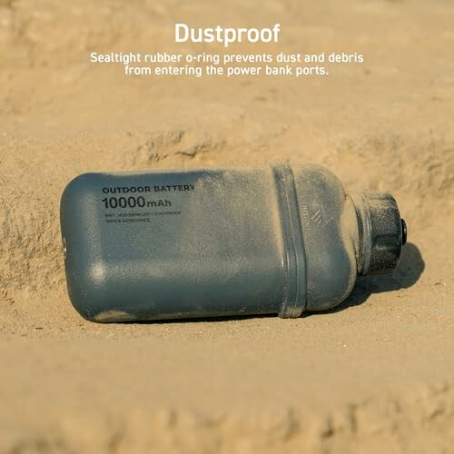ELECOM NESTOUT Rugged Power Bank with 10000mAh capacity lying on sand, showcasing dustproof feature.