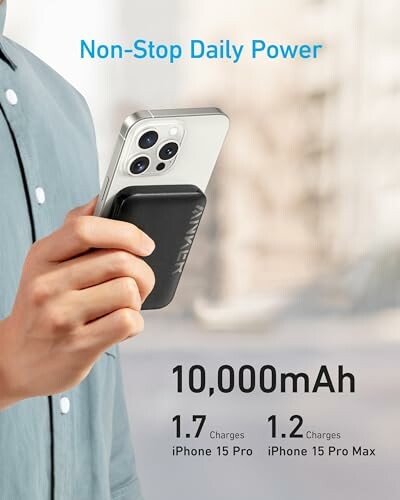 Person holding an iPhone with a portable charger attached, showing charging capacity.