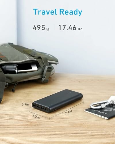 Portable power bank with travel bag and passport on table.