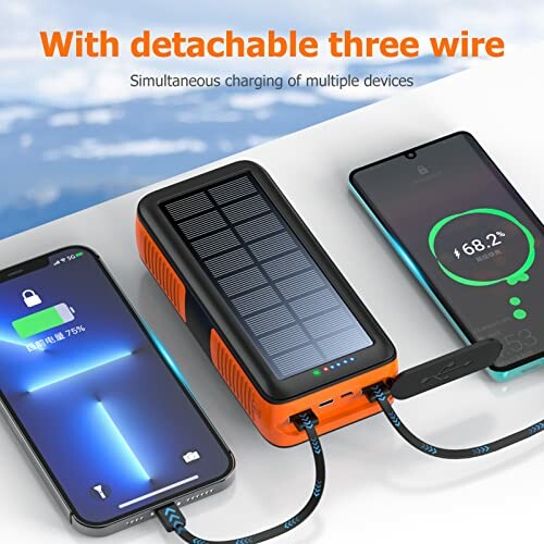 Solar power bank charging two smartphones with detachable cables.